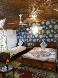 a bedroom with two beds and a ceiling at Houseboat Young Snow View Front Line Dal Lake in Srinagar