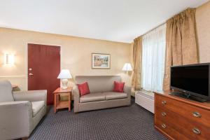 um quarto de hotel com um sofá e uma televisão de ecrã plano em Lancaster Suites em Lancaster
