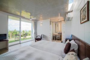 a bedroom with a large bed and a large window at 413 Hamahiga Hotel＆Cafe in Uruma