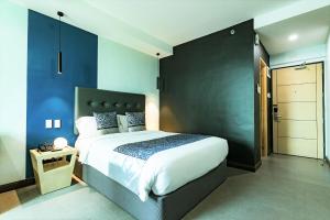 a bedroom with a large bed and a blue wall at Bay Area Suites Manila in Manila