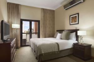 A bed or beds in a room at Hawthorn Suites by Wyndham Abuja