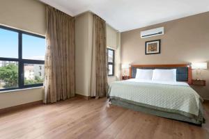 A bed or beds in a room at Hawthorn Suites by Wyndham Abuja