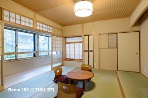 Zimmer mit einem Tisch, Stühlen und Fenstern in der Unterkunft Luck You Kyoto in Kyoto