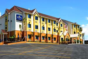 a large yellow building with a parking lot at Microtel Inn & Suites by Wyndham New Braunfels I-35 in New Braunfels