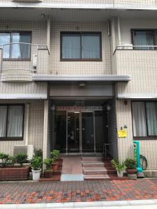 a building with a front door with potted plants at Business Hotel Urbanty Nishikujo in Osaka