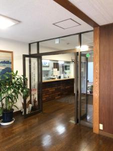 a lobby with glass doors and a potted plant at Business Hotel Urbanty Nishikujo in Osaka