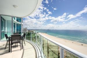 a balcony with a table and chairs and a view of the beach at Reflection on the Sea in Gold Coast