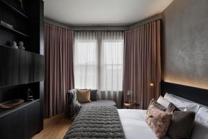 オークランドにあるHotel Fitzroy curated by Fableの大きなベッドと窓のある寝室