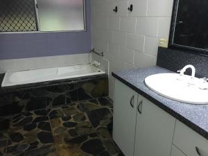 a bathroom with a sink and a bath tub at Royal Palm Cottage, Entire two bedroom 2 bathroom house with Pool in Mission Beach