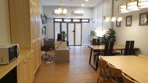 a room with tables and chairs and a dining room at Nature Village Hostel in Lak Si