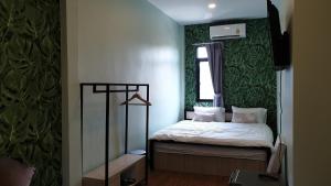 a small bedroom with a bed and a window at Nature Village Hostel in Lak Si