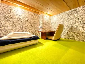 1 dormitorio con cama, escritorio y silla en Guest House MARUYA en Atami