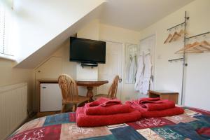 a bedroom with a bed with a red blanket on it at Abacus Bed and Breakfast, Blackwater, Hampshire in Farnborough