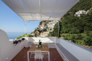 balcón con mesa y vistas al océano en CASA BAKER luxury apartment, en Positano
