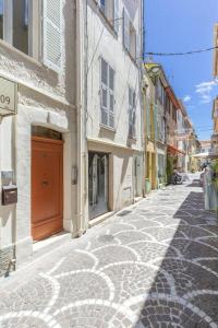 アンティーブにあるBNB RENTING Chez Dominique - Studio 2-4pers centre Antibes Fourmilliere 1erの建物の赤い扉付き石畳の通り