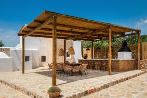 a wooden pavilion with a table and chairs on a patio at Can Mateu in Santa Eularia des Riu