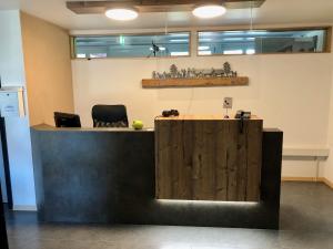 ein Büro mit einer Holztheke und 2 Stühlen in der Unterkunft Gästehaus Sonne in Bütschwil