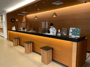 a restaurant with a counter with a person behind it at Nishitetsu Inn Nihonbashi in Tokyo