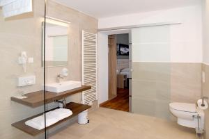 un bagno con lavandino e WC di Landhotel Reitingblick a Gai