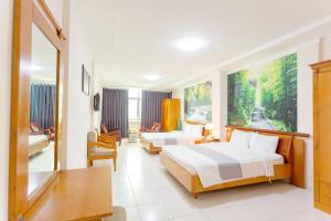 Una habitación de hotel con dos camas y una sala de estar. en Giang Linh Hotel, en Ho Chi Minh