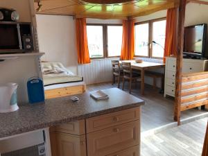 eine Küche und ein Esszimmer mit einem Bett und einem Tisch in der Unterkunft Bungalow Ostseeblick in Insel Poel