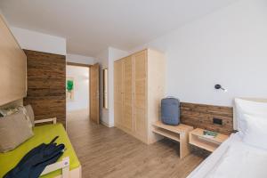 1 dormitorio con 1 cama y pared de madera en Residence Plan De Corones, en San Vigilio Di Marebbe