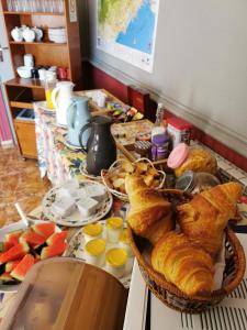 una mesa con pan, bollería y fruta. en La Chaumiere, en Agde