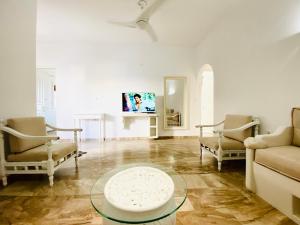 a living room with a couch and chairs and a table at Deluxe Studios & Suites Ageri-Milos in Adamantas