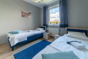 a bedroom with two beds and a window at Nautical Sea Apartment in Gdynia