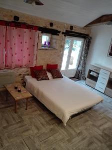 a bedroom with a large white bed and a table at Les Rosiers in Chaunay