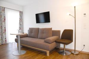 sala de estar con sofá y silla en Landhotel Reitingblick, en Gai