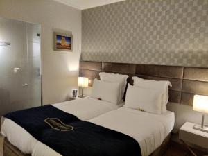 ein Hotelzimmer mit einem großen Bett und zwei Lampen in der Unterkunft Seven Dreams Suites in Lissabon