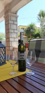 a bottle of wine and two wine glasses on a table at Apartments Angela in Žbandaj