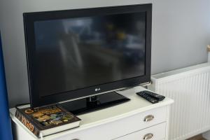 a flat screen tv sitting on top of a dresser at Nautical Sea Apartment in Gdynia