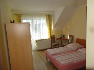 a bedroom with a bed and a table and a window at Ośrodek Korab in Władysławowo
