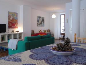 ein Wohnzimmer mit einem grünen Sofa und einer Schale mit Kiefernzapfen in der Unterkunft Namaste in Grazalema