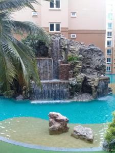 - une cascade au milieu d'une piscine dans un bâtiment dans l'établissement Atlantis Condo Resort Атлантис кондо резорт, à Jomtien Beach