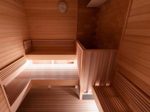 an empty sauna with a clock on the wall at ONSEN RYOKAN Yuen Sapporo in Sapporo