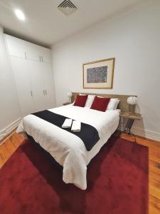 1 dormitorio con 1 cama grande con alfombra roja en Heritage 313 Auckland en Auckland