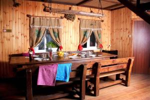 een eetkamer met een houten tafel en een bank bij Дом с баней для отпуска in Nyzhni Mlyny