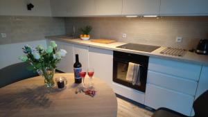 een keuken met een tafel met wijnglazen en bloemen bij Apartamenty MARITIME Struga Park Ustka in Ustka