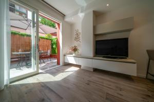 een woonkamer met een televisie en een glazen schuifdeur bij Smart House S.Orsola - Garage & Garden in Bologna
