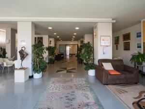a lobby with couches and potted plants at Hotel Europa in Senigallia