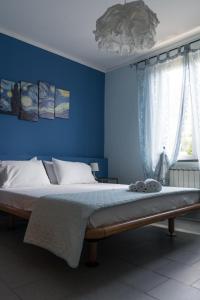 リッコ・デル・ゴルフォ・ディ・スペーツィアにあるB&B La Fontanellaの青い壁のベッド付きの青いベッドルーム1室