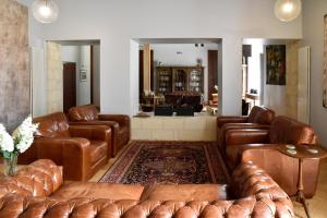 a living room with brown leather couches at Chateau De Jalesnes in Vernantes