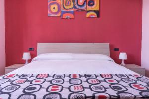 リッコ・デル・ゴルフォ・ディ・スペーツィアにあるB&B La Fontanellaの赤い壁の白いベッドが備わるベッドルーム1室