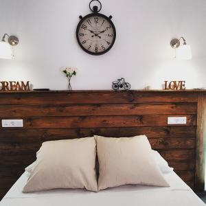 a clock on a wall above a bed with pillows at El Nogal Home in Málaga