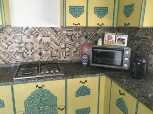 a kitchen counter with a microwave and a stove at Arabesque Style - 2 appartements in Kelibia