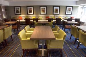 a dining room table with chairs and tables in it at Holiday Inn Express Edinburgh Airport, an IHG Hotel in Ingliston
