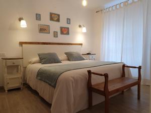 a bedroom with a bed with a chair and a window at El Nogal Home in Málaga